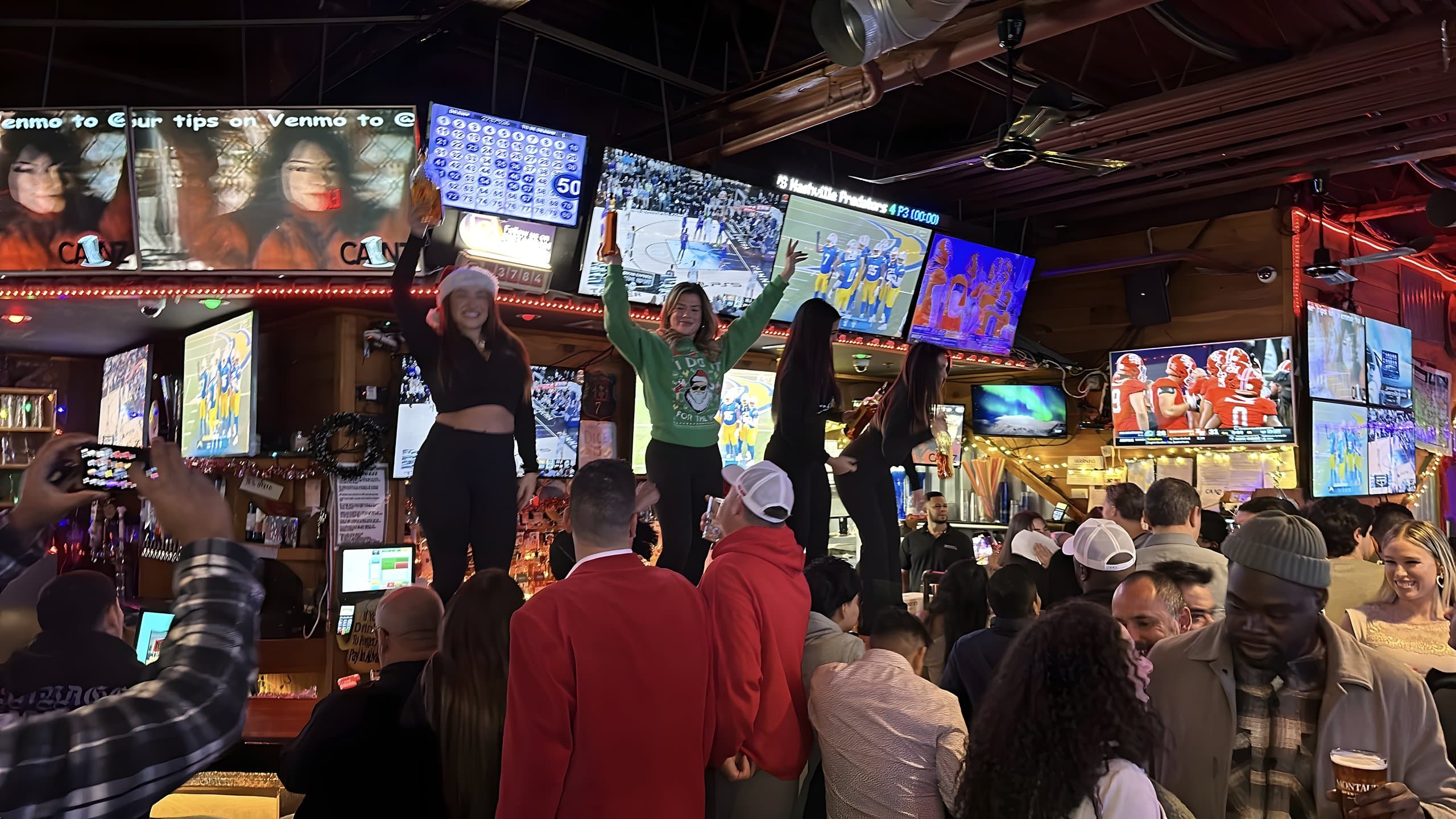 A packed holiday crowd cheering under the screens at Canz Westbury
