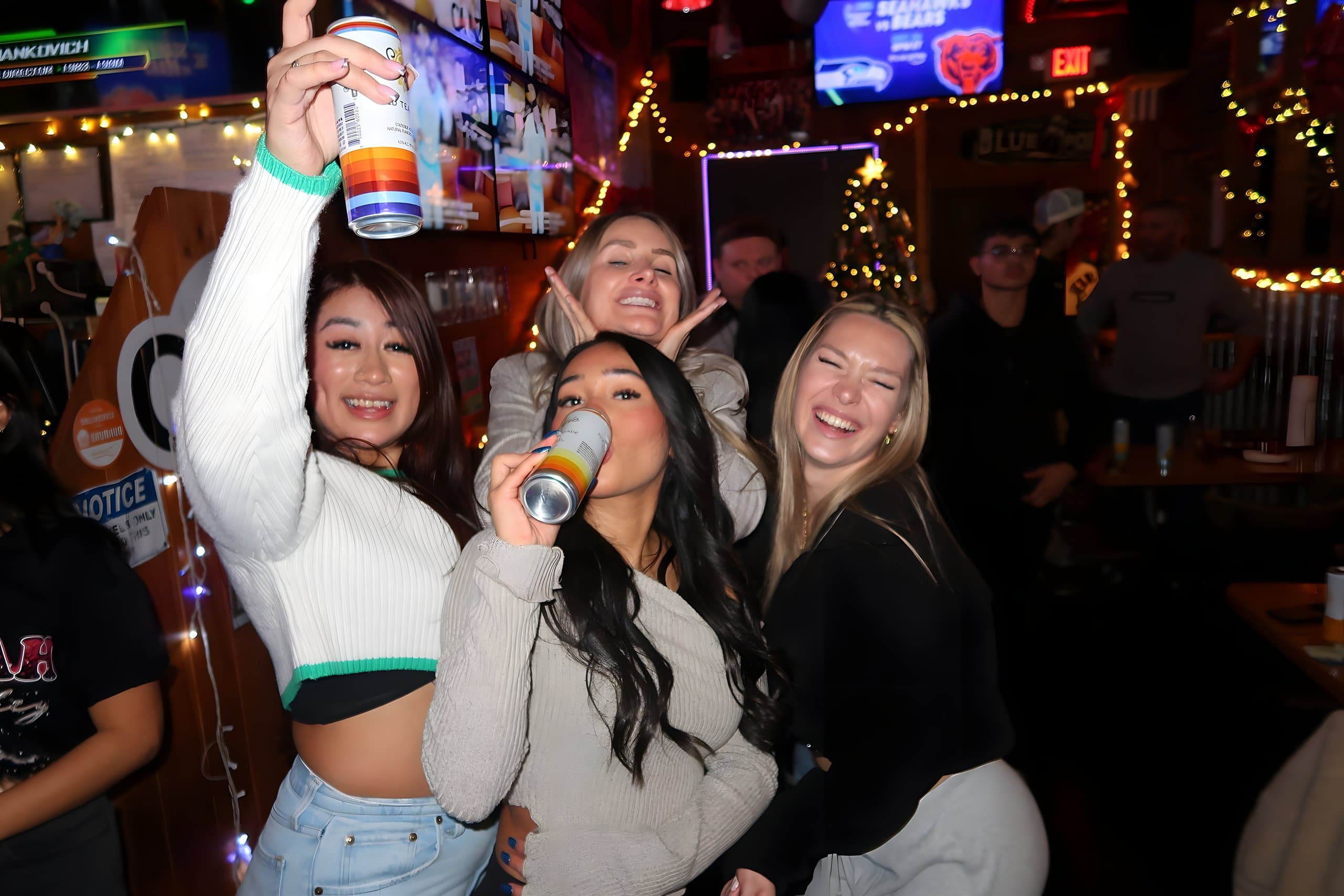 Friends celebrating at the bar under holiday lights