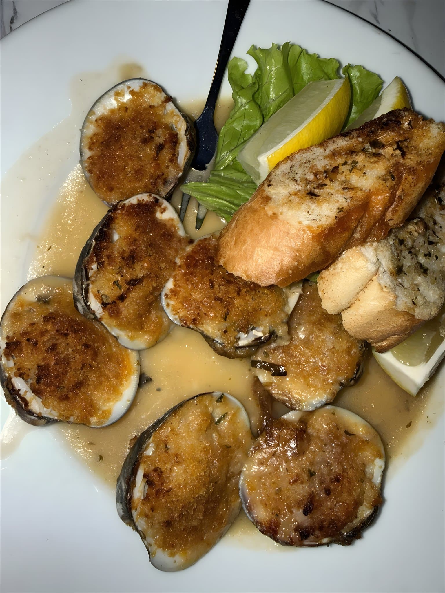 Baked clamz oreganata with garlic bread and lemon