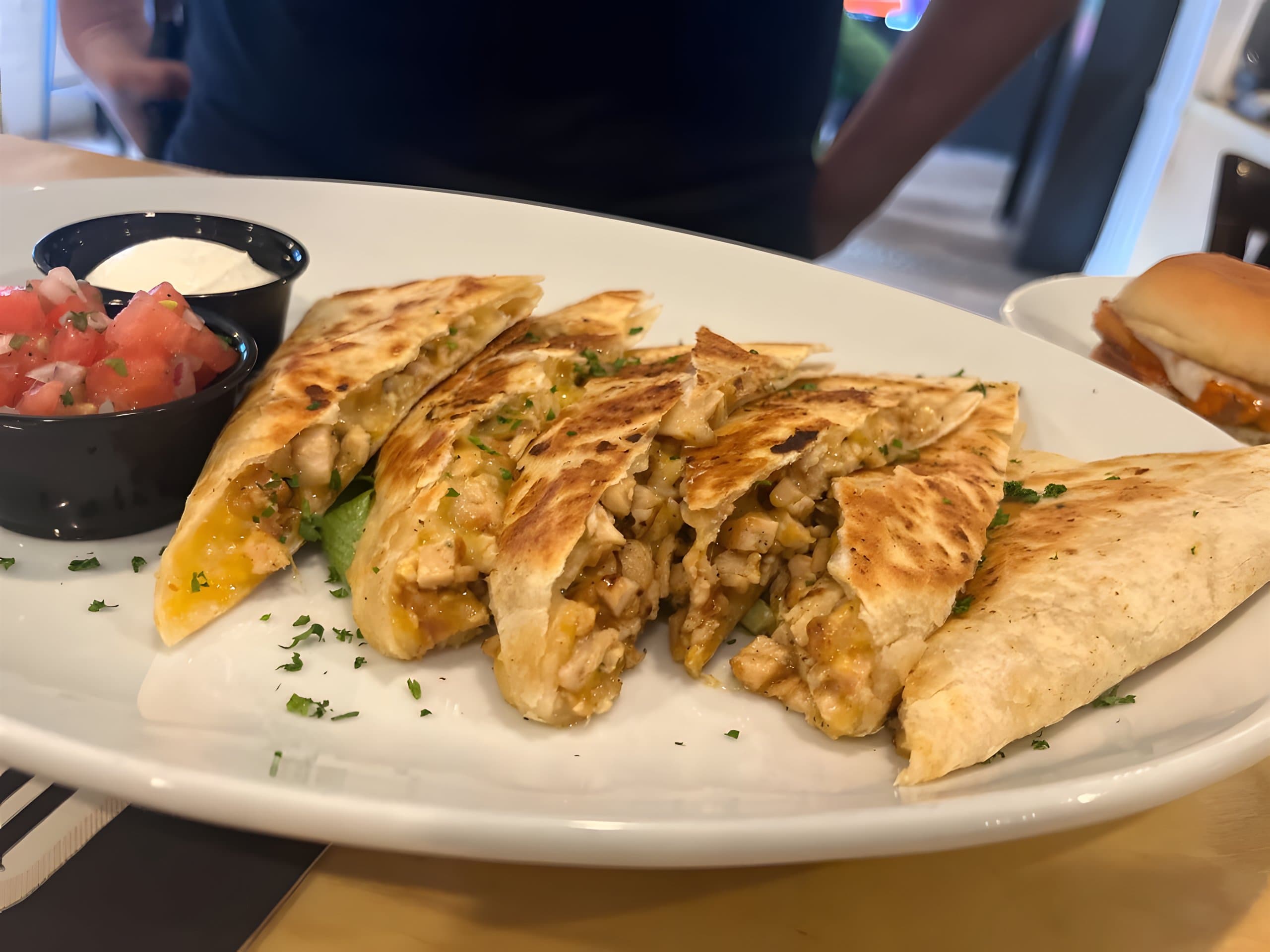 Canz quezadilla with grilled chicken, cut into wedges, with pico de gallo and sour cream
