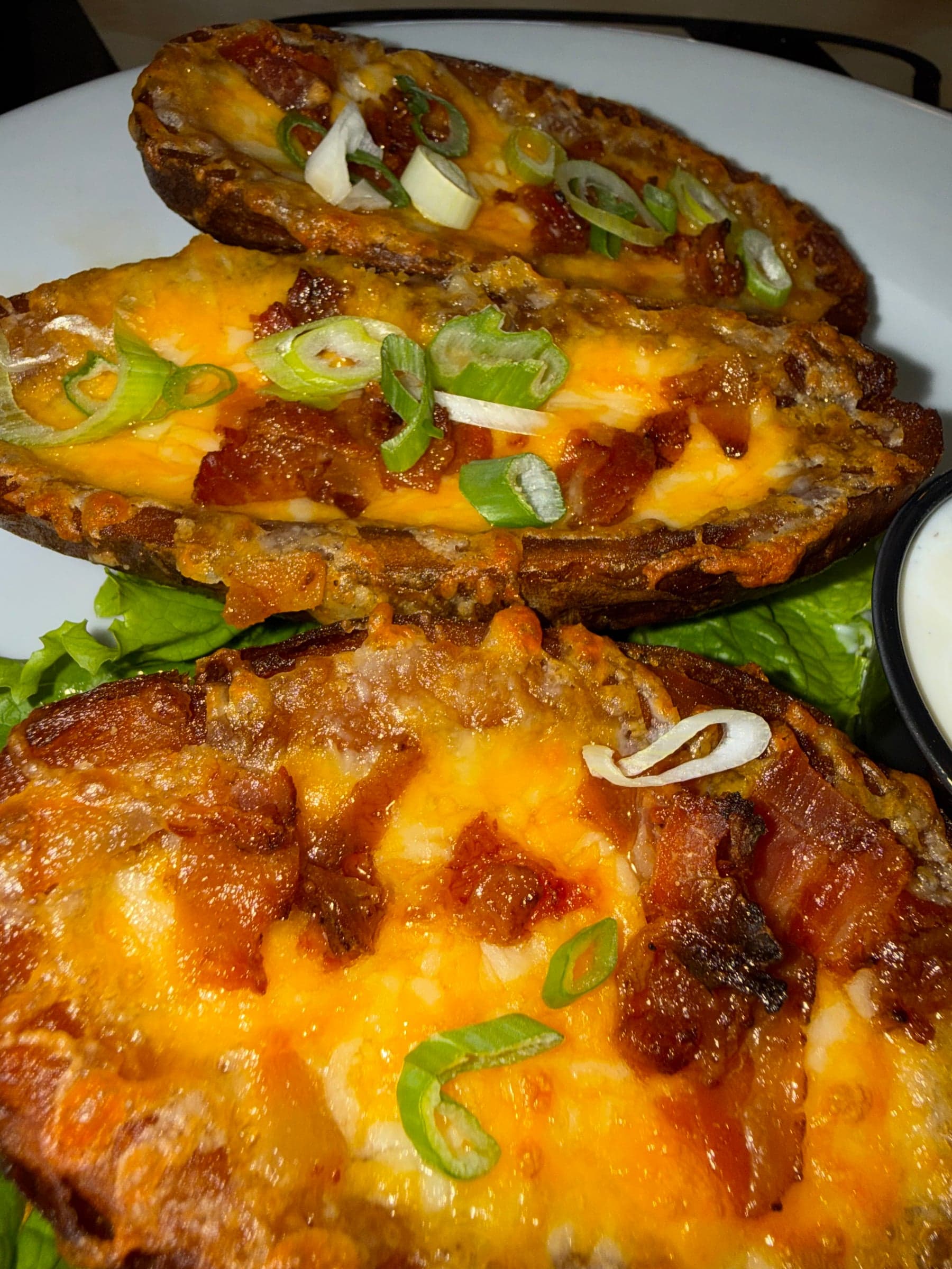 Potato skinz loaded with melted cheddar jack, crispy bacon and scallion, with sour cream on the side